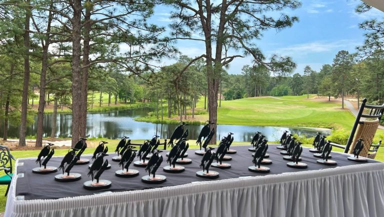 Trophies at Forest Creek Golf Course lined up with the course in the background.